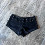 Short negro de tiro alto con detalle de argollas metálicas en la cintura.