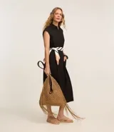 Vestido chemise de lino color negro, con cuello camisero, sin mangas y cierre frontal con botones. Incluye cinturón de tela estampado.