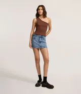 Minifalda de denim de tiro medio, color celeste claro, con tachas metálicas aplicadas en los bordes de los bolsillos delanteros y trabillas.