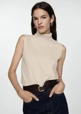 Top color beige de tejido de punto con cuello alto y sin mangas.