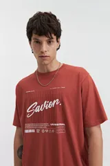 Remera blanca de manga corta con estampado frontal que incluye la palabra 'Savior' en letras cursivas negras y otros textos en tipografía sans-serif. Corte regular.