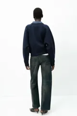 Chaqueta bomber azul marino de tejido de punto con cuello solapa de cuero sintético a contraste y manga larga. Cierre frontal con cremallera metálica.