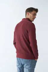 Buzo negro de algodón con cuello alto y medio cierre. Tiene logo bordado en el pecho y puños en las mangas.