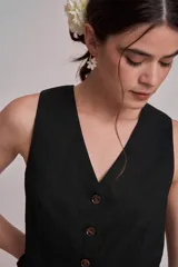 Chaleco marrón con escote en V y cierre frontal con botones.