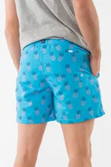 Short de baño azul con estampado de hojas de palmera en tonos azules, blancos y rosados.