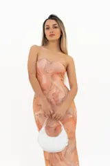 Vestido largo ajustado al cuerpo, sin tirantes (strapless), con estampado que simula mármol o batik en tonos anaranjados y rosados.