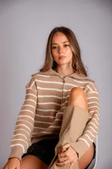 Sweater de punto color beige con rayas horizontales blancas, cuello polo con cierre de cremallera y mangas largas.