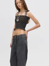 Top corto negro con textura fruncida, tirantes finos con lazos ajustables y corte crop.