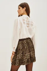 Minifalda plisada con estampado animal print de leopardo, con volados en el dobladillo.