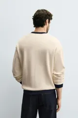Sudadera de hombre color crudo con estructura waffle, corte relaxed fit, cuello redondo, manga larga y ribete en cuello, puños y bajo en color azul marino.