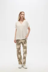 Blusa color beige de lino, holgada y con cuello en V.