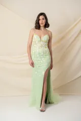 Vestido largo de tul bordado con motivos florales en tonos verdes. Tiene breteles finos cruzados en la espalda y tajo lateral.