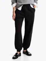 Joggers negros de felpa de mezcla de algodón con pierna cónica, cintura elástica con cordón, dos bolsillos laterales ribeteados y logo de Tommy Hilfiger bordado en el muslo.