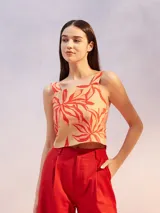 Musculosa corta color beige con estampado de hojas rojas, breteles anchos y escote cuadrado.