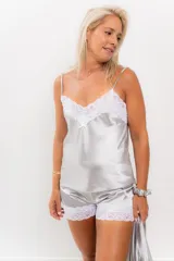 Pijama de satén elastizado color champagne, compuesto por musculosa con escote en V y detalle de puntilla elastizada, y short con elástico en la cintura y terminación con puntilla.