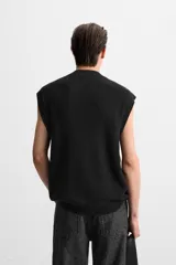 Chaleco de punto color crema con cuello en V y sisas.