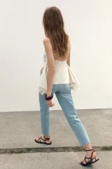 Pantalón de jean rosado, de tiro alto, corte mom leg y largo tobillero.