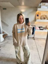 Sweater azul marino de tejido grueso, corte oversize y hombros caídos, con un bordado frontal que representa la bandera de Argentina.