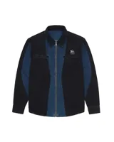 Camisa de denim negro y azul con cortes curvos y simétricos, cierre frontal de alpaca, cuello en cuero vacuno y bolsillos delanteros con bordado del logo Temblad.