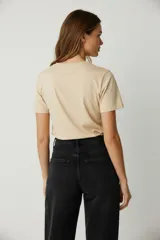 Remera color beige con estampado de cerezas y texto en negro.