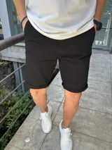 Bermuda negra de gabardina con lycra, corte a la rodilla y ruedo doblado.