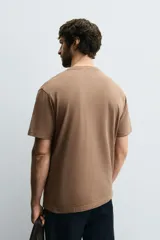 Camiseta color marrón de corte recto, cuello redondo y manga corta.