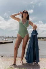 Traje de baño entero color verde claro con textura y ribete blanco.