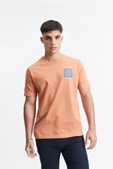 Remera color salmón de manga corta con cuello redondo y estampado en el pecho.