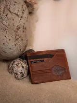 Tarjetero de cuero marrón con siete ranuras para tarjetas y forro interior inspirado en los rebeldes. Presenta un diseño del Halcón Milenario y el logo de Lucasfilm Ltd. Producto hecho a mano con cuero de primera calidad.
