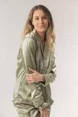 Conjunto de pijama color champagne, confeccionado en satén elastizado. Incluye una camisa de manga larga con botones y un pantalón recto con elástico y lazo en la cintura.