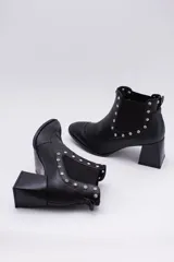 Botas cortas negras de cuero con elásticos laterales, taco cuadrado y apliques de tachas plateadas.
