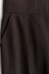 Pantalón de vestir marrón de punto con pinzas, tiro alto con cintura elástica, bolsillos al bies y piernas amplias con raya adelante.