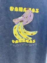 Remera azul con efecto gastado y estampa amarilla con la palabra "BANANAS".
