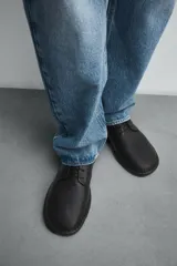 Zapato de cordones tipo derby, color negro, con capellada de cuero abatanado, plantilla de cuero y suela ultrafina.