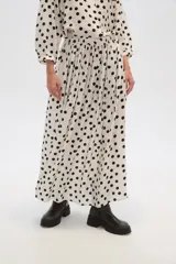 Falda larga de viscosa con estampado de lunares negros sobre fondo blanco y cintura elastizada.
