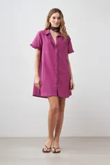 Vestido camisero corto color fucsia, con cuello camisero, mangas cortas con volados y cierre frontal con botones.