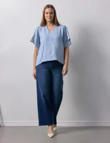 Blusa color beige de crepe, marca Batía, con cuello a la base y escote en V. Manga corta amplia con bordados.