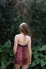 Vestido corto turquesa con escote halter y espalda descubierta. El cuello es alto y las tiras se atan en la nuca.