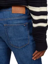 Jeans Bleecker de Tommy Hilfiger, confeccionados en algodón lavado para mayor comodidad y con elasticidad para un ajuste flexible. Diseño de 5 bolsillos, cierre con botón y cremallera, detalles distintivos de Tommy Hilfiger y logo de Tommy Hilfiger bordado.