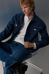 Pantalón de jean de corte recto, color azul medio, con cinco bolsillos y cierre con botón y cremallera. Confeccionado en denim de algodón con leve stretch.