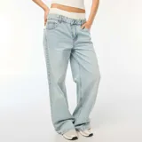 Pantalón jean celeste de corte ancho, tiro alto y efecto calzoncillo a la vista.