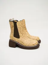 Botas Chelsea color beige con estampado floral, elástico lateral marrón y suela track color marrón.