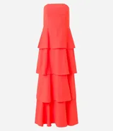 Vestido largo sin breteles, color naranja, hecho en crepé. Tiene lastex en la espalda y capas superpuestas en la pollera.