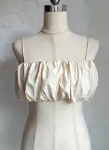 Top corto color crema con breteles finos y fruncido en el busto.