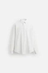 Camisa blanca con estampado de cuadros en tonos grises, corte regular fit, cuello italiano, manga larga con puños abotonados y cierre frontal con botones.