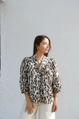Camisa de manga larga con cuello mao y estampado animal print en tonos crudo, negro y marrón.
