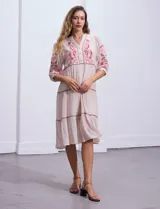 Vestido midi color crema, con bordados florales en el frente y mangas 3/4.