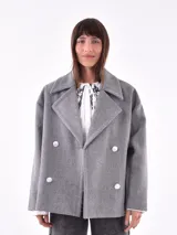 Tapado gris con doble botonadura, cuello solapa y corte holgado.