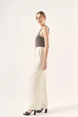 Pantalón palazzo negro de tiro alto, confeccionado en cupro y viscosa. Cuenta con bolsillos diagonales laterales, bolsillos ojal falsos en la espalda y cierre lateral invisible.