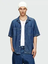 Camisa de jean Diesel modelo D-Paroshort, de manga corta y calce holgado. Tiene dos bolsillos frontales con solapa y cierre con botones.
